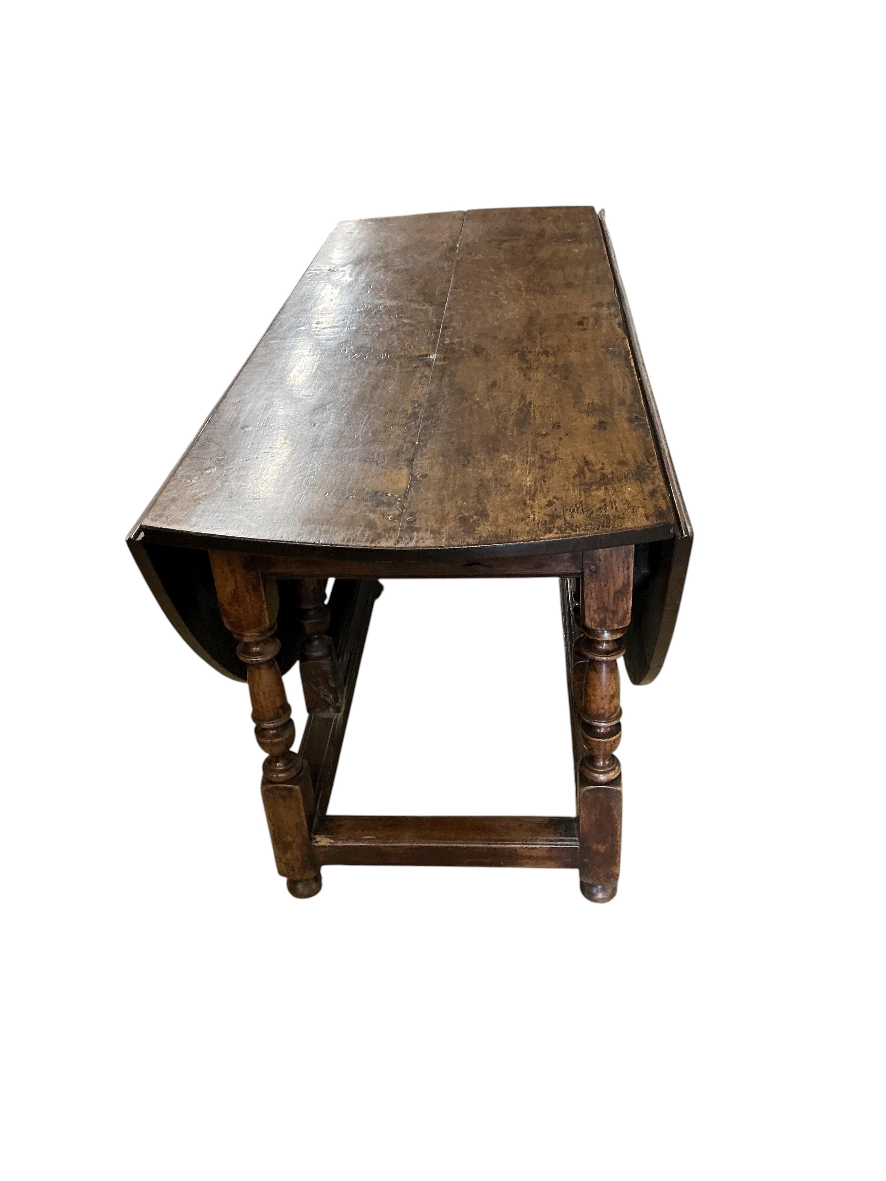 An early 17th century style oak gateleg dining table incorporating earlier elements, width 151cm, depth 62cm, height 75cm